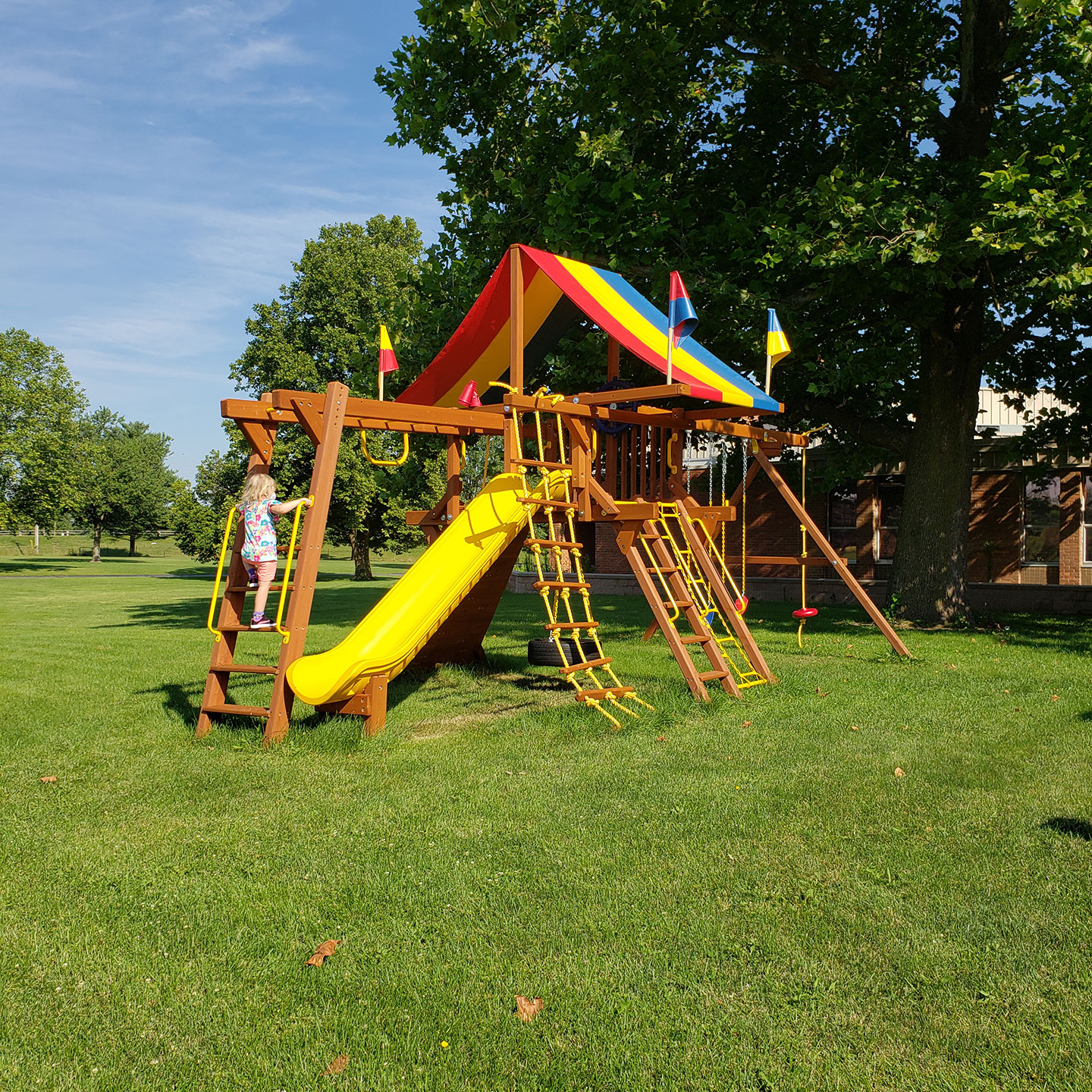 The Calvary United Methodist Church Community Playground with a child on the step latter leading to the monkey bars